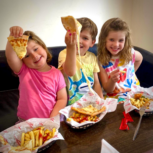 Kids eating pizza and chips at Conifox